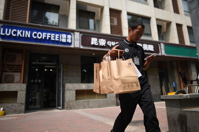 COFFEE CHAIN. A deliveryman walks out of a Luckin Coffee branch in Beijing, China, on August 2, 2018. File photo by Wang Zhao/AFP 