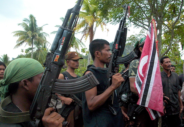 Kombatan GAM memegang senjata saat diliput jurnalis di Bireun, Aceh, pada 29 Agustus 2005 silam. Foto oleh EPA 