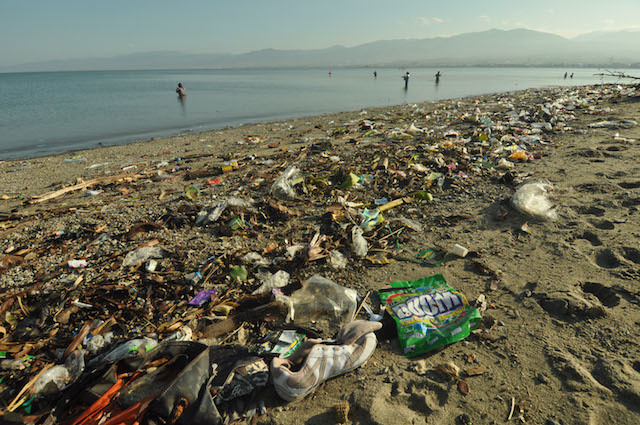 SAMPAH PLASTIK. Nelayan berada didekat tumpukan sampah yang menumpuk di Pantai Teluk Palu, Sulawesi Tengah, Rabu, 13 Januari, 2016. Foto oleh Mohamad Hamzah/ANTARA 