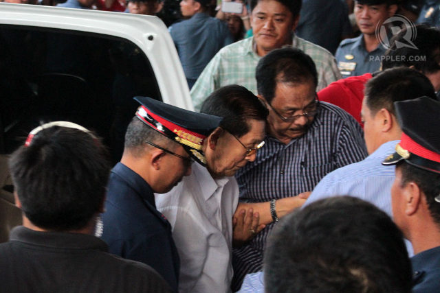 BATTLING PNEUMONIA. Senator Juan Ponce Enrile is assisted by his aides as he makes his way to court prior to his hospital arrest.  File photo by  Joel Leporada/Rappler  