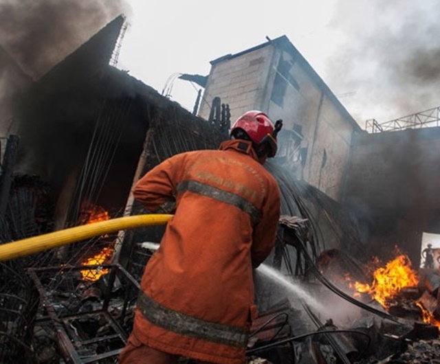 KEBAKARAN APARTEMEN. Ilustrasi petugas pemadam kebakaran tengah memadamkan api. Foto oleh Rosa Panggabean/ANTARA
