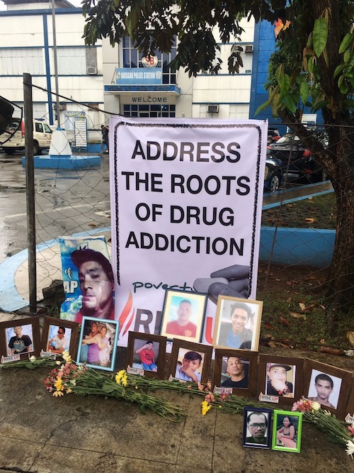 ADDRESS THE PROBLEM. Kin of victims of the drug war leave this poster outside the Batasan Police Station, along with photos of the victims. Photo by Eloisa Lopez/Rappler  