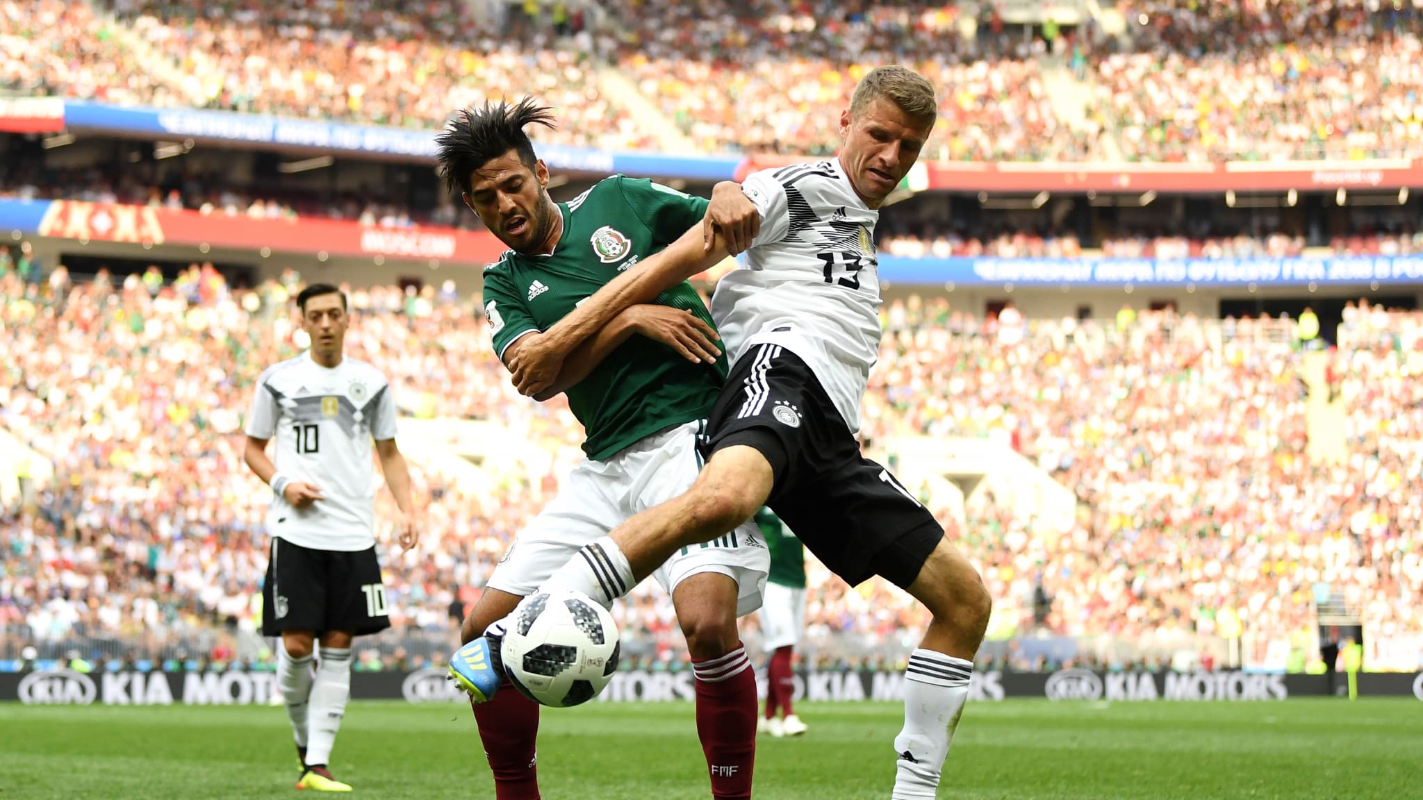 DI LUAR DUGAAN. Thomas Mueller (Jerman) berebut bola dengan Carlos Vela (Meksiko). Di luar dugaan, juara bertahan harus takluk dari Meksiko di pertandingan perdana grup F. Foto oleh FIFA.com 