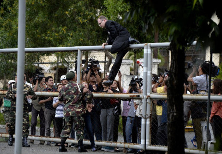 'MEDIA CIRCUSES'? German Marc Sueselbeck, boyfriend of murdered transgender Filipino Jennifer Laude, 26, climbs the gate of the facility where Private First Class Joseph Scott Pemberton is detained at the Armed Forces of the Philippines headquarters in Manila on October 22, 2014. US Ambassador to the Philippines Philip Goldberg criticizes this as part of 'media circuses.' Photo by Noel Celis/AFP