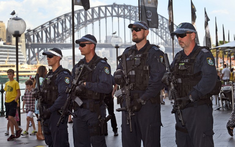 LAPSE. Members of the New South Wales (NSW) state riot squad police carry machine guns as they patrol on Sydney's Circular Quay on December 18, 2017. Photo William West/AFP 