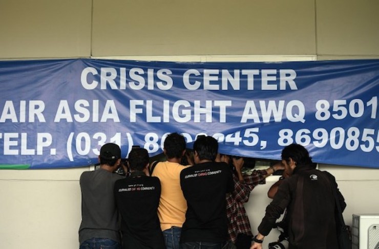 Gerombolan wartawan mencoba mengambil gambar keluarga korban AirAsia QZ8501 di Crisis Center Bandara Juanda, Surabaya, pada 29 Desember 2014. Foto oleh Manan Vatsyayana/AFP
