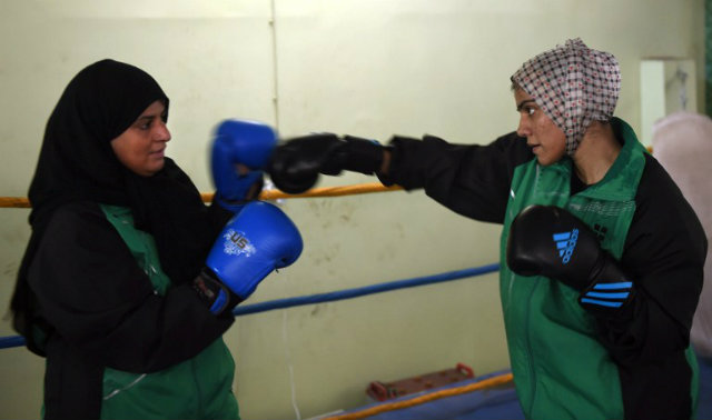 In this photograph taken on October 6, 2016, 19-year-old Pakistani boxer Razia Banu (R) throws a punch at her mother Haleema Abdul Aziz during a practice session at the Pak Shaheen Boxing Club in Karachi. ASIF HASSAN / AFP 