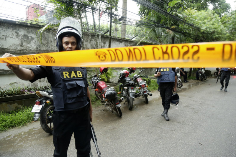 Members of the Rapid Action Batallion (RAB) behind tape to resrict media and others in the streets close to the Holey Artisan Bakery in Dhaka, Bangladesh 02 July 2016. Six gunmen have been shot and killed during an operation to end a hostage situation by military commandos, while two policemen were killed by the gunmen earlier and more than 20 people were injured. EPA/STRINGER 