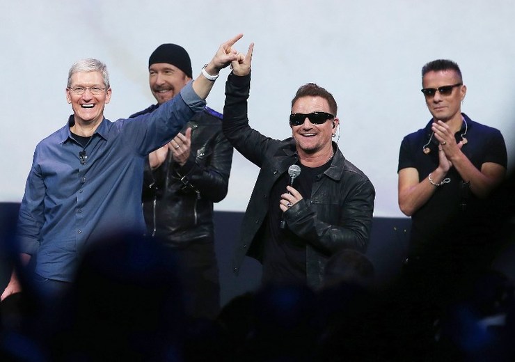 SURPRISE PARTNERS. Apple CEO Tim Cook (L) greets the crowd with U2 singer Bono (2nd R) as The Edge (2nd L) and Larry Mullen Jr look on during an Apple special event at the Flint Center for the Performing Arts on September 9, 2014 in Cupertino, California. Justin Sullivan/Getty Images/AFP