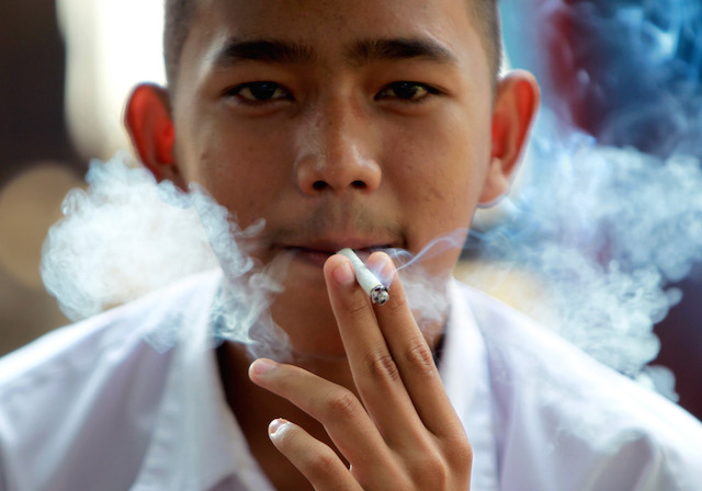 TOBACCO CONTROL? An Indonesian junior high school student smoking a cigarette after class in Bogor, Indonesia. Photo by Adi Weda/EPA 