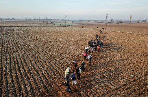 FLEE ON FOOT. Migrants walk towards Greece along the Turkey-Greece border near Pazarkule, in Edirne district, on March 1, 2020. Photo by Bulent Kilic/AFP 