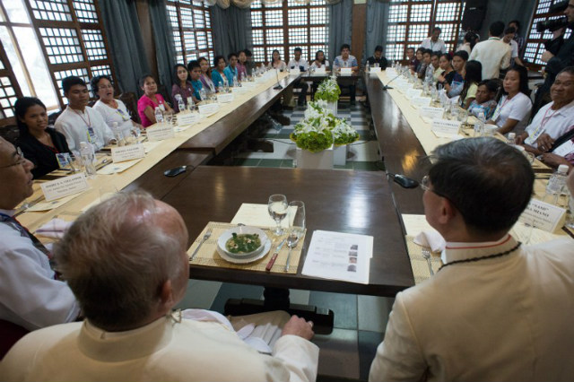 LUNCH WITH SURVIVORS. In this handout picture released by the Vatican Press Office, Pope Francis (left) shares a meal with disaster survivors in Palo, Leyte, on January 17, 2015, as part of his trip to the Philippines. Photo courtesy of Osservatore Romano/AFP