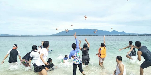 ANIMAL ABUSE. Palawan authorities are looking for the people in this photo caught playing with live starfish in a Palawan beach supposedly in late October 2018. Photo from Palawan Supernews Facebook Page  