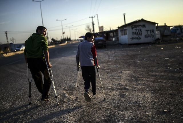 THE ONCUPINAR BORDER AREA. Two wounded friends Muhammed (L) from Aleppo and Ahmed (R) from Idlib in Syria, walk in the refugee camp near the Oncupinar crossing gate in Kilis, in south-central Turkey, on February 15, 2016. File photo by Bulent Kilic/ AFP 
