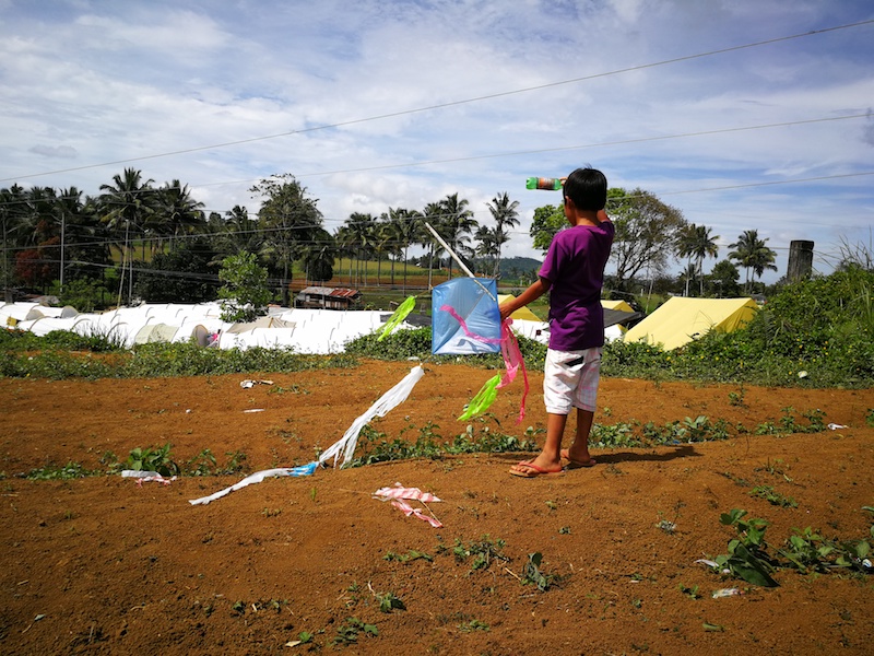 FLYING A KITE. A child flies his kite on one of the many fields within the community. Many children have resorted to this hobby since their relocation.