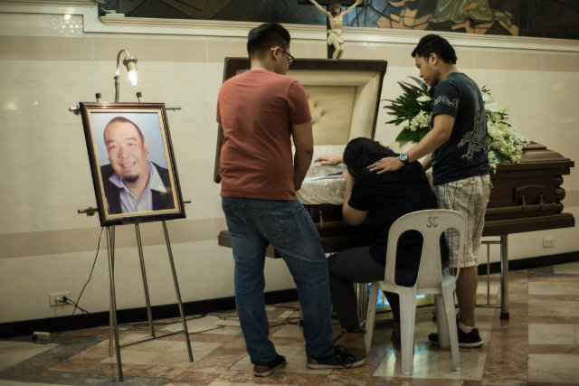 GRIEVING. Queenie Vivero weeps in front of her dead husband JR Rosales, who was shot by unidentified men on October 26, 2016. Photo by Carlo Gabuco/Rappler 