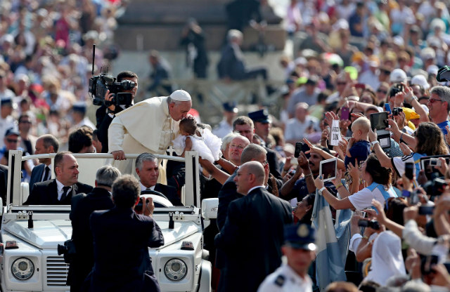 PEOPLE'S POPE. Pope Francis kisses a child as he arrives at the general audience in St Peter's Square in Vatican City on September 10 2014. Photo by Alessandro di Meo/EPA