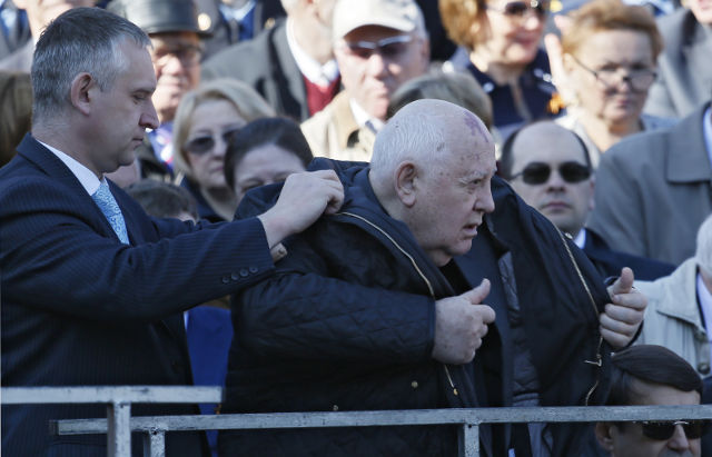 GORBACHEV. A man helps former Soviet leader Mikhail Gorbachev (front R) to put on a coat prior to a military parade marking the 69th anniversary of the victory over the Nazi Germany in the WWII in the Red Square in Moscow, Russia 09 May 2014. Yuri Kochetkov/EPA