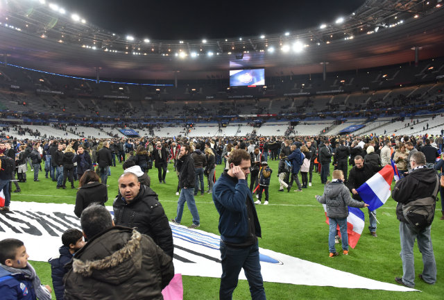 Spectators gather on the pitch of the stadium after the international friendly soccer match between France and Germany at Stade de Fance in Paris. Photo by UWE ANSPACH/EPA  