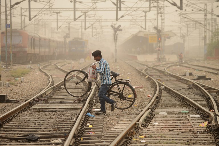 HAZE. An Indian commuter crosses railway tracks as dust covers sky in Jalandhar on June 15, 2018. Air pollution soared in New Delhi on June 14 to hazardous levels rarely seen outside winter months as sand blown from deserts enveloped the Indian capital in a once-in-a-decade phenomenon. Photo by Shammi Mehra / AFP 