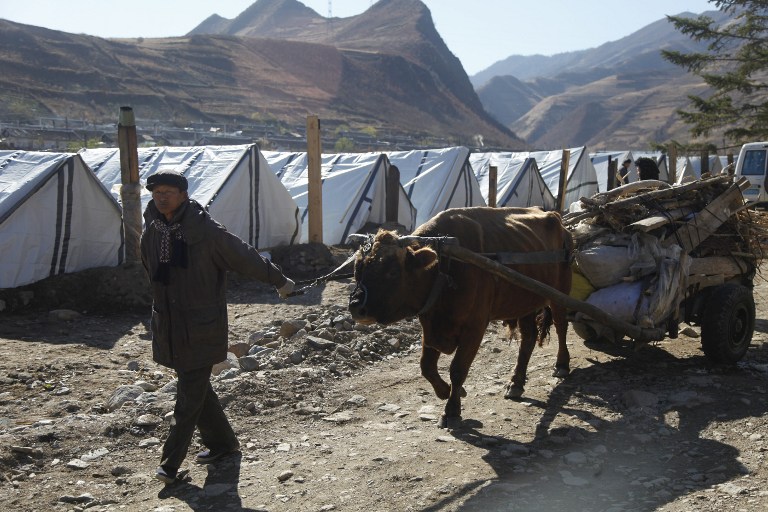 RECOVERY. This recent undated handout photo received by the Finnish Red Cross on October 29, 2016 shows a man leading an ox and cart past temporary housing in an area devastated by flooding last August in Musan County in North Korea's North Hamgyong Province. STR/Finnish Red Cross/AFP 