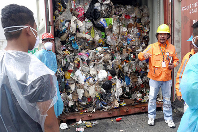 DUMPED IN THE PHILIPPINES. Environment officials open one of around 100 container vans of garbage shipped illegally from Canada. Photo courtesy of BAN Toxics