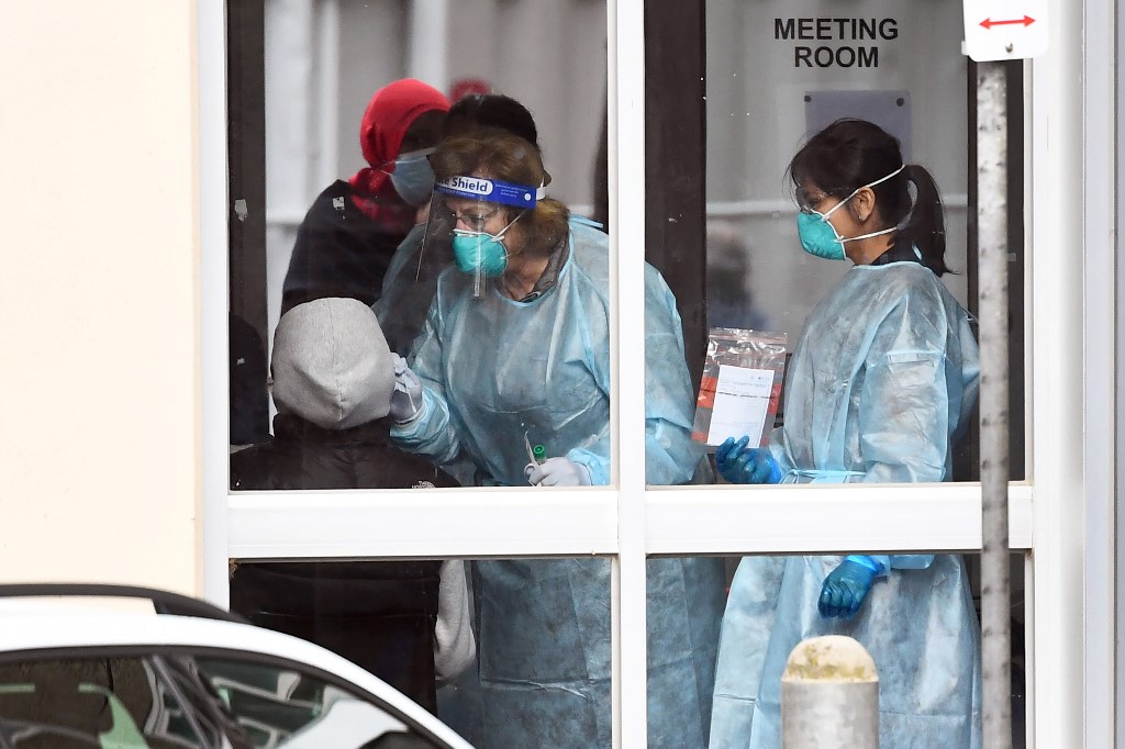 MASS TESTING. Medical staff perform a COVID-19 coronavirus test on a resident of one of9 public housing estates locked down due a spike in infection numbers in Melbourne on July 6, 2020. Photo by William West/AFP 