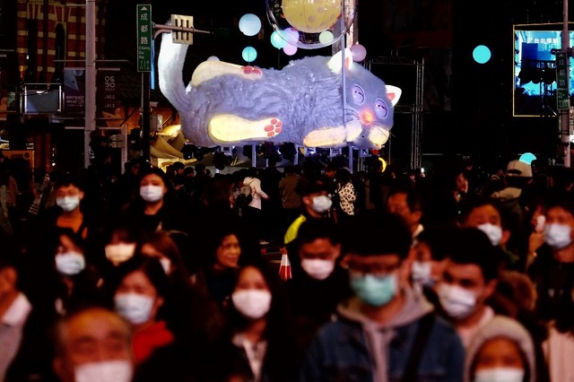 PROTECTION. People wearing protective face masks walk past a cat-shaped lantern during the lunar lanterns festival following the Lunar New Year in Taipei on February 8, 2020. Photo by Sam Yeh/AFP 