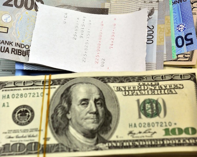 RUPIAH DOLAR. Dolar Amerika diletakkan berdampingan dengan rupiah di tempat penukaran uang di Jakarta, September 2011. Lepas dari paket ekonomi yang diluncurkan Jokowi, belum ada perbaikan signifikan terhadap nilai tukar rupiah. Foto oleh Bay Ismoyo/AFP 