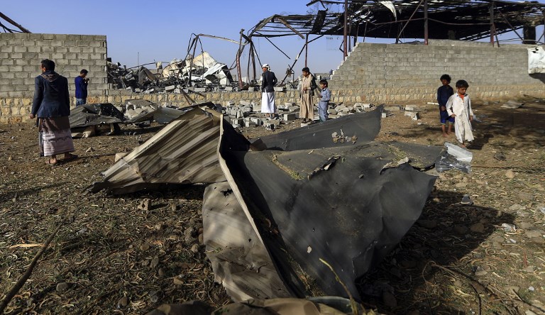 Civilians inspect the damage at a factory after a reported airstrike by Saudi-led coalition in the Yemeni capital Sanaa, on January 20, 2019. - Coalition spokesman Turki al-Maliki said in Riyadh that the alliance launched an "operation to destroy multiple military targets", including seven bases across Sanaa. Targets included drone storage and testing areas, training bases, and bomb-manufacturing facilities. (Photo by Mohammed HUWAIS / AFP)  