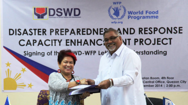 DSWD Secretary Corazon Juliano-Soliman and World Food Program Country Director Praveen Agrawal exchange documents during the Signing Ceremony for the Letter of Understanding between the DSWD and the UN-WFP on Disaster Preparedness and Response Capacity Enhancement Project.