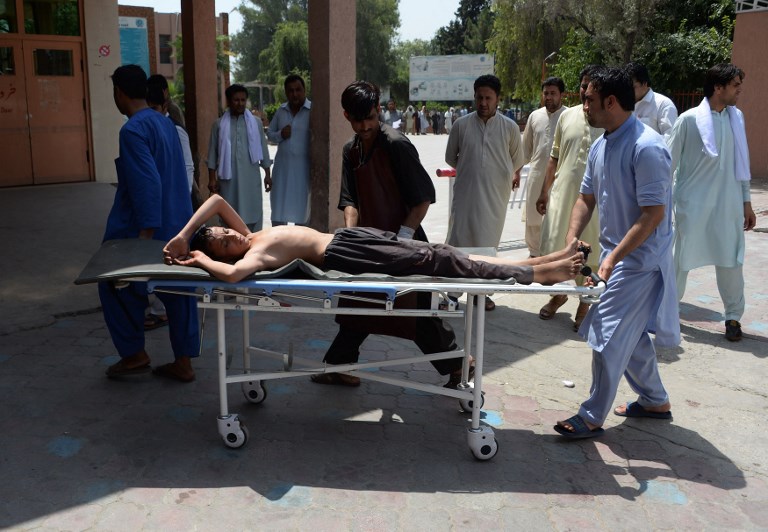 TARGETED. Afghan volunteers carry an injured youth on a stretcher to a hospital following an attack that targeted an education department compound in Jalalabad on July 11, 2018. Photo by Noorullah Shirzada / AFP 