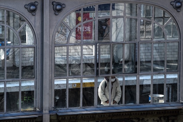 LOCKED. A woman wearing a face mask looks through the windows of the La Chapelle metro station as she waits on the platform on March 27, 2020, in Paris. Photo by Joel Saget/AFP 