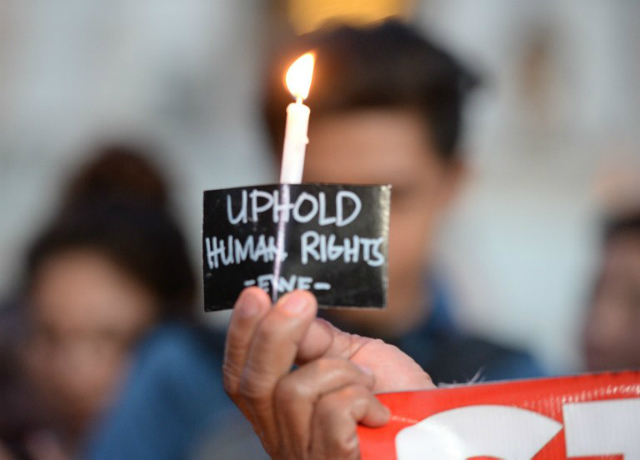 PRAYING FOR VICTIMS. Activists hold a candle-light vigil on September 16, 2016, for victims of recent extrajudicial killings in the Philippines. File photo by Ted Aljibe/AFP