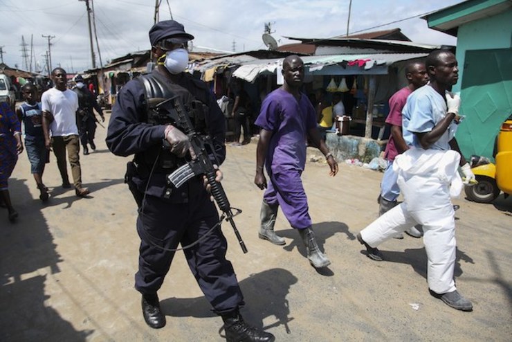 UNDER HEAVY GUARD. Liberian soldiers deployed to assist nurses retrieve looted items from the MV Massaquoi Elementary school that was used as an Ebola isolation unit in West Point, Monrovia, Liberia, 19 August 2014. Ahmed Jallanzo/EPA