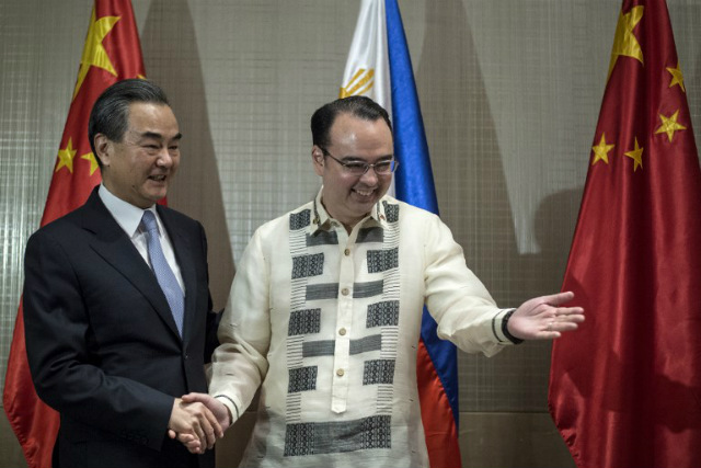 TOP DIPLOMATS. Chinese Foreign Minister Wang Yi (L) shakes hands with Philippine Foreign Secretary Alan Peter Cayetano (R) after signing the guestbook in Manila on July 25, 2017. Photo by Noel Celis/AFP  