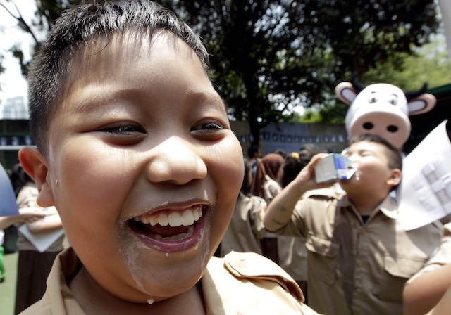 Seorang anak tersenyum setelah menikmati susu dalam peringatan World School Milk Day 2013 di Jakarta, 25 September 2013. Foto oleh Bagus Indahono/EPA 