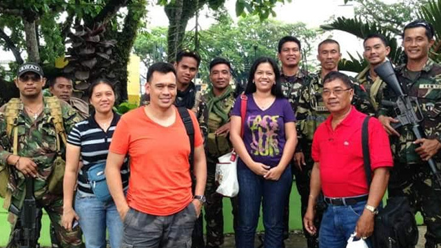 HELPING ABU SAYYAF VICTIMS. Lt Col 'Tiny' Perez (left, in orange shirt) with soldiers and civilians in Basilan. Photo courtesy of Zhiela Ritz Gatchalian 