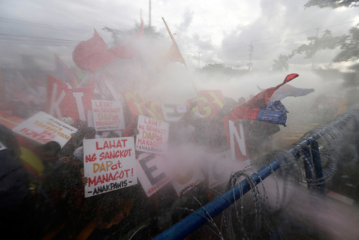 PROTESTS. Anti-riot policemen use water cannon to disperse protestors attempting to reach the Philippine Congress in Quezon City on 28 July 2014, during the state of the nation address (SONA). Photo by Dennis Sabangan/EPA