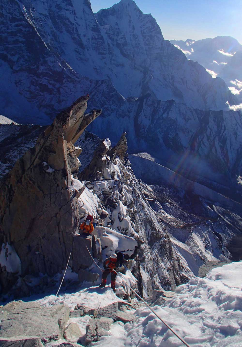 The team climbs the rocky face of Ama Dablam, with the aid of ropes laid out by their sherpa guides  