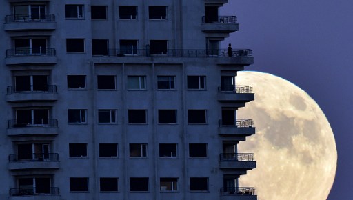 Seorang warga Spanyol menikmati superoon di atas balkon di sebuah gedung di Madrid, Senin (13/11). Foto oleh GERARD JULIEN/AFP 