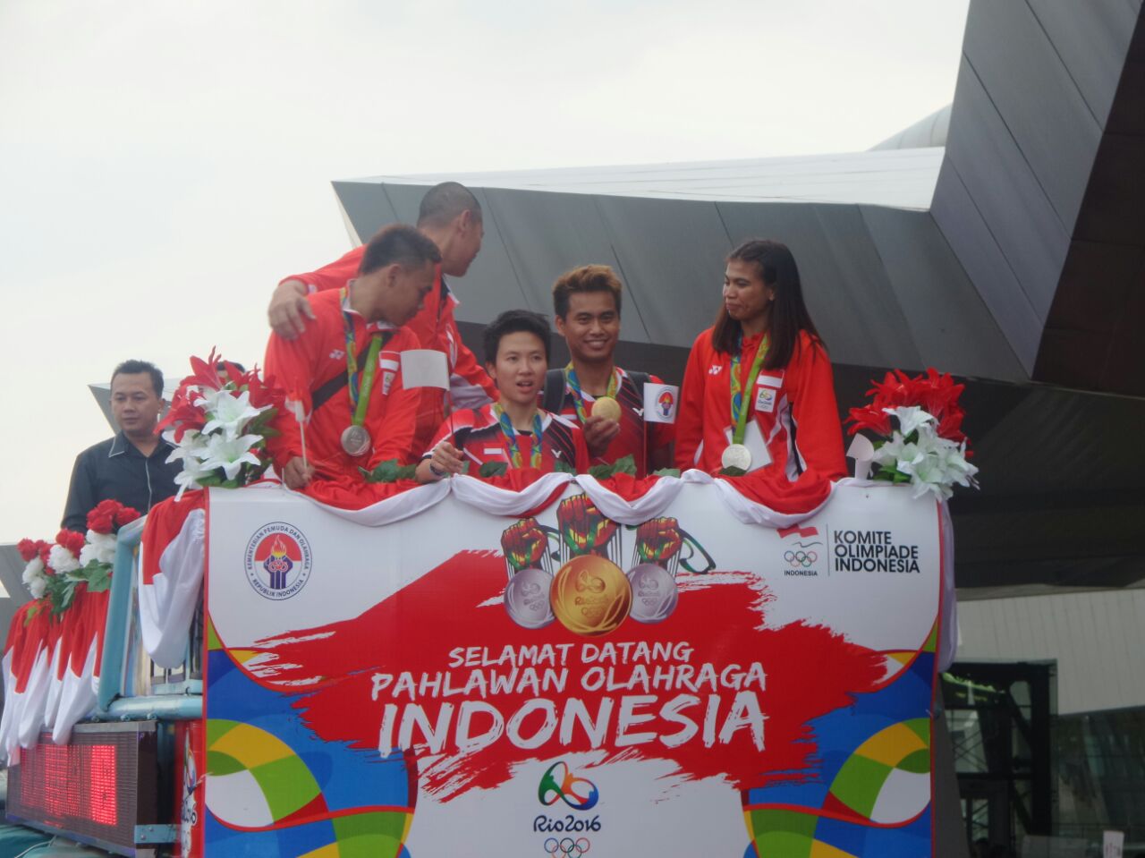 Peraih medali perak dan emas untuk Indonesia di Olimpiade Rio 2016 berada di atas bus Bandros. Mereka tiba di Jakarta pada Selasa, 23 Agustus sore. Foto oleh Twitter @Kemenpora_RI 
