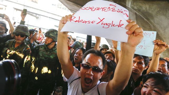 ANTI-COUP. A Thai demonstrator shouting slogans holds a sign in support of former Prime Minister Yingluck Shinawatra during a protest against the military coup in Bangkok, Thailand, 24 May 2014. Photo by Diego Azubel/EPA