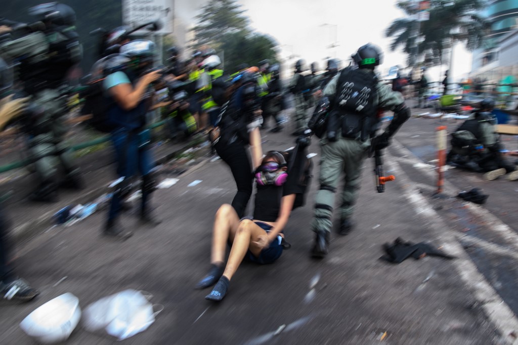 ARRESTED. Police drag a protester along a road after they detained her during as attempt to escape the campus of the Hong Kong Polytechnic University in the Hung Hom district of Hong Kong on November 18, 2019. Photo by Anthony Wallace/AFP 
