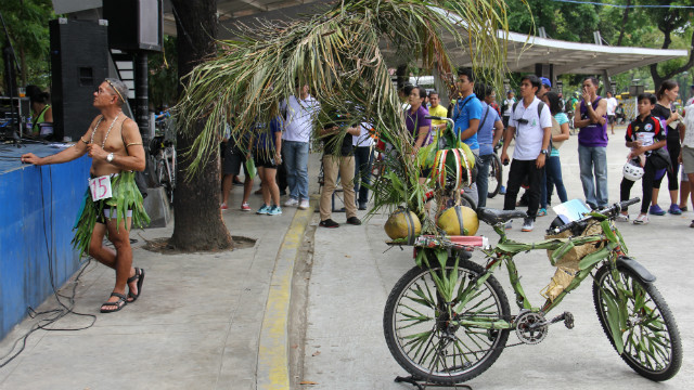 UNUSUAL. A bike covered with green paper and leaves draws the attention from a crowd. All photos by Alain Fusana 