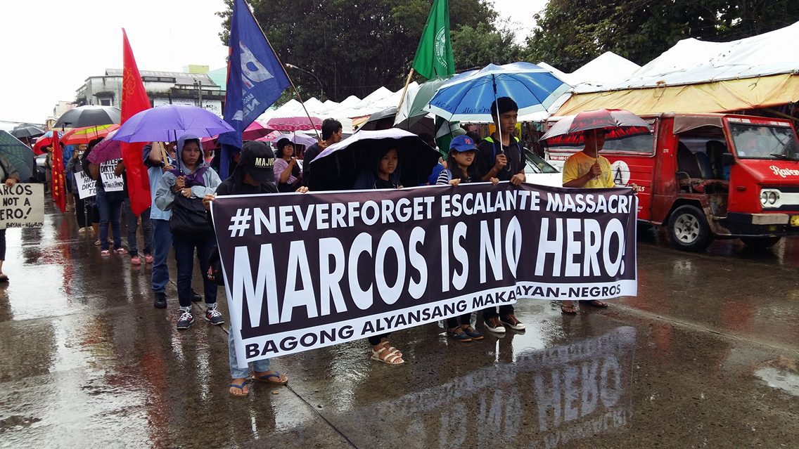 BRAVING THE RAINS. Protesters in Negros Occidental march from the San Sebastian Cathedral to the Fountain of Justice in Bacolod City to express indignation over a hero's burial for dictator Ferdinand Marcos. Photo by Marchel Espina/Rappler 