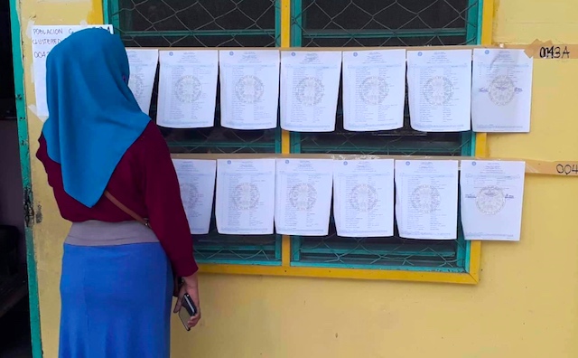 BOL PLEBISCITE. A woman looks for her name in the voters' list at the Midsayap Pilot Elementary School in North Cotabato, on February 6, 2019. Photo from Comelec  