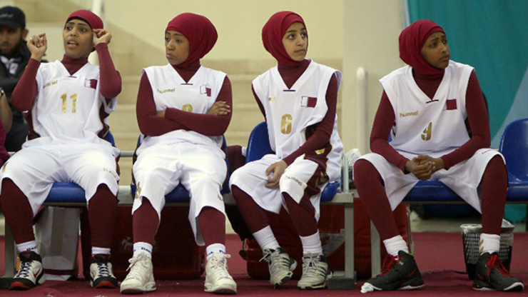Qatari players wearing Islamic headscarves especially designed for women sit on the bench during their 2011 Arab Games basketball match against Lebanon in 2011. Photo by Marwan Naamani/AFP