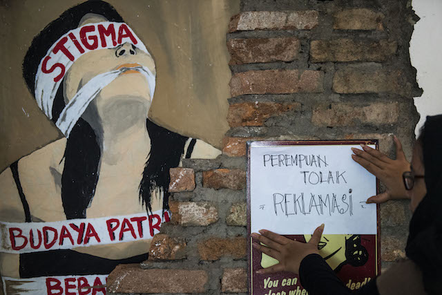 TOLAK REKLAMASI. Seorang aktivis Solidaritas Perempuan menempelkan kertas penolakan reklamasi saat Deklarasi Gerakan Perempuan Tolak Reklamasi di Jakarta, pada 13 Maret 2016. Foto oleh M Agung Rajasa/Antara  