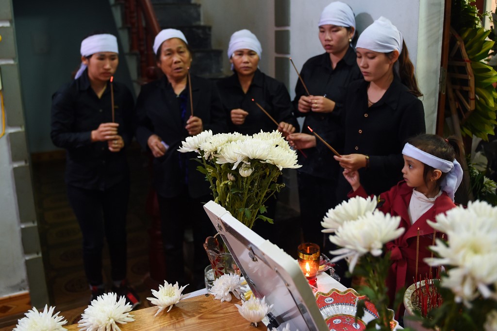 GRIM HOMECOMING. Family members of Hoang Van Tiep before a coffin bearing his remains during a funeral in Dien Chau district, Nghe An province on November 28, 2019. Photo by Nhac Nguyen/AFP  